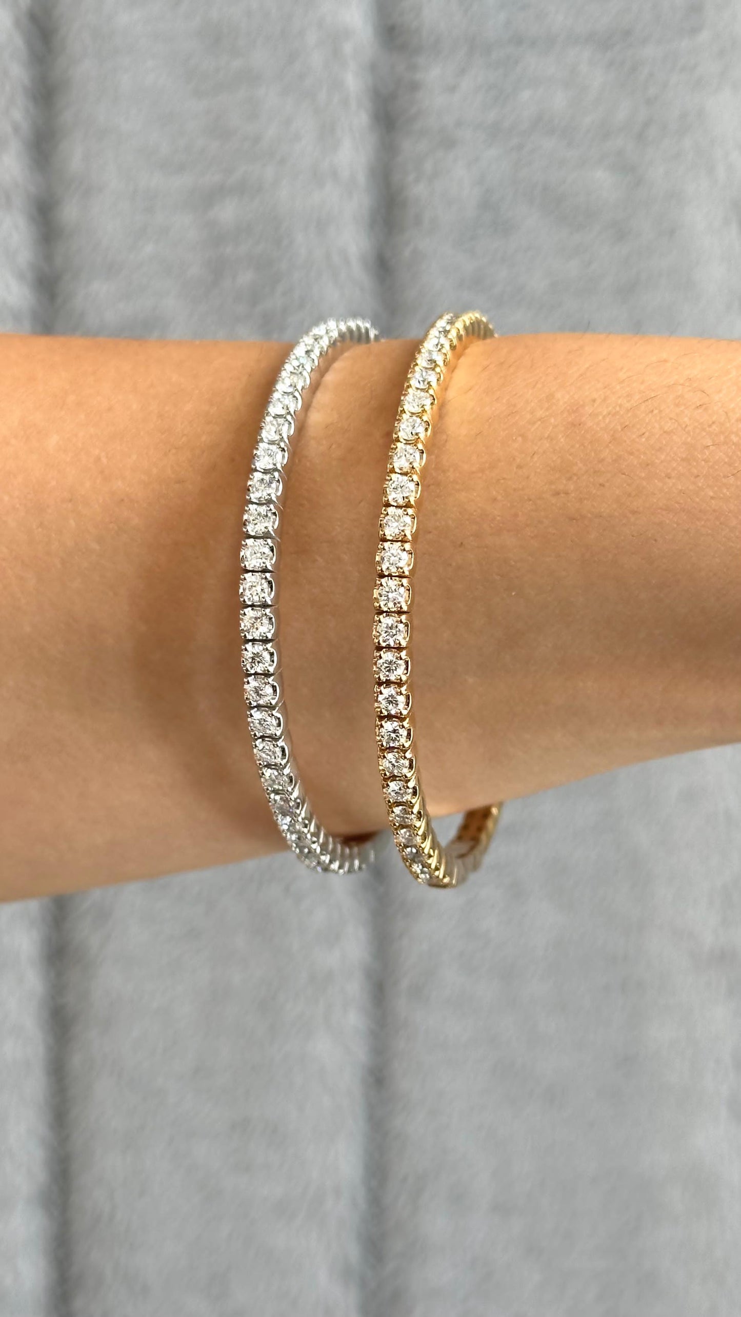 Lifestyle shot showing a platinum or white gold and yellow gold flexible bangle on the wrist of a model