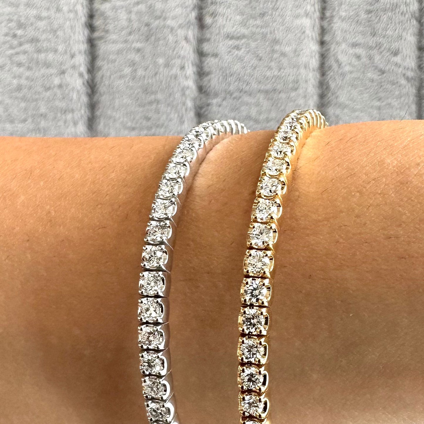 close up lifestyle shot showing a platinum or white gold and yellow gold flexible bangle on the wrist of a model