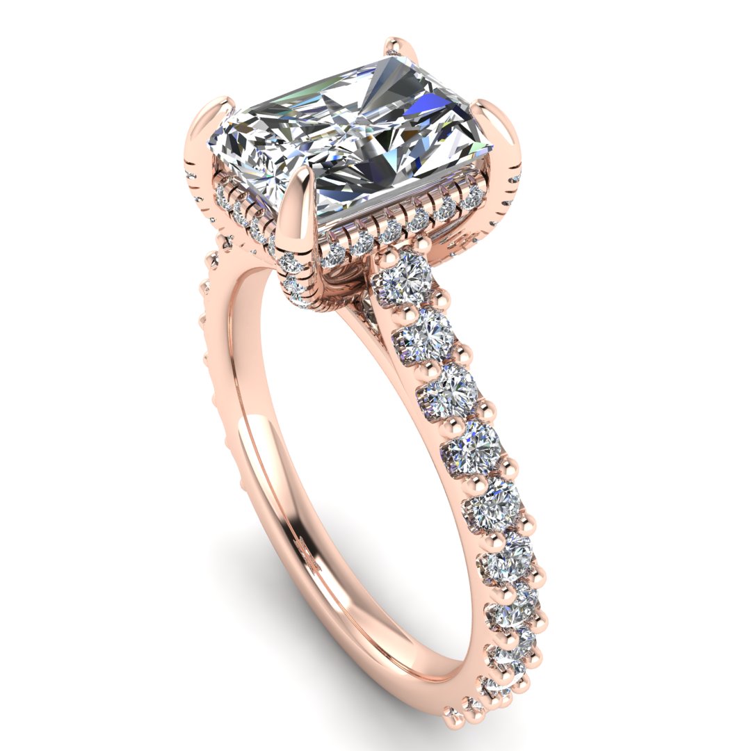 angled view of Ellie rose gold engagement ring which has a central emerald cut lab grown diamond, elegant under-halo, pavé-set shoulders, and delicate diamonds on the prongs for extra sparkle