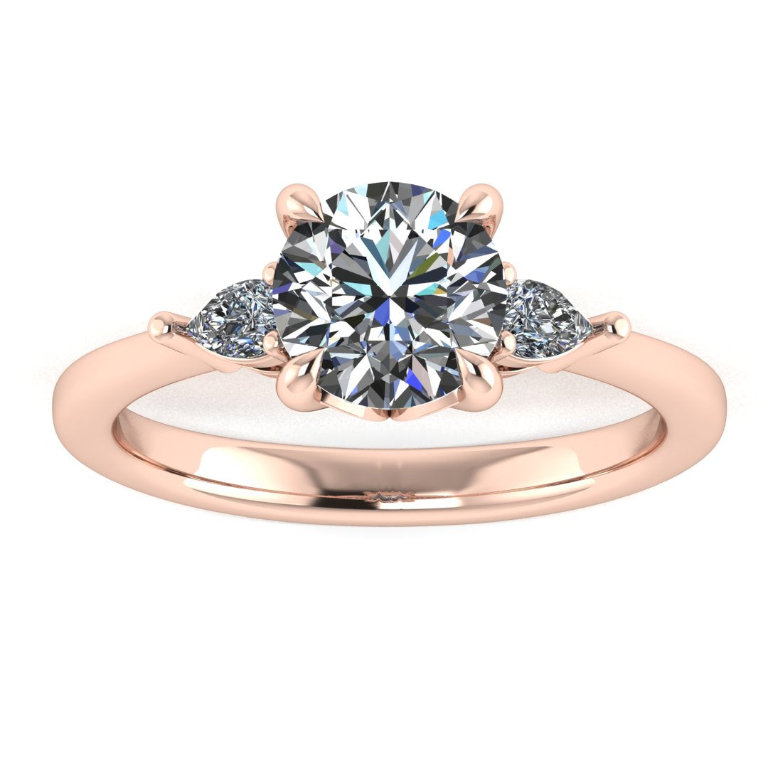Front view of a rose gold trilogy engagement ring using round and pear shaped lab grown diamonds