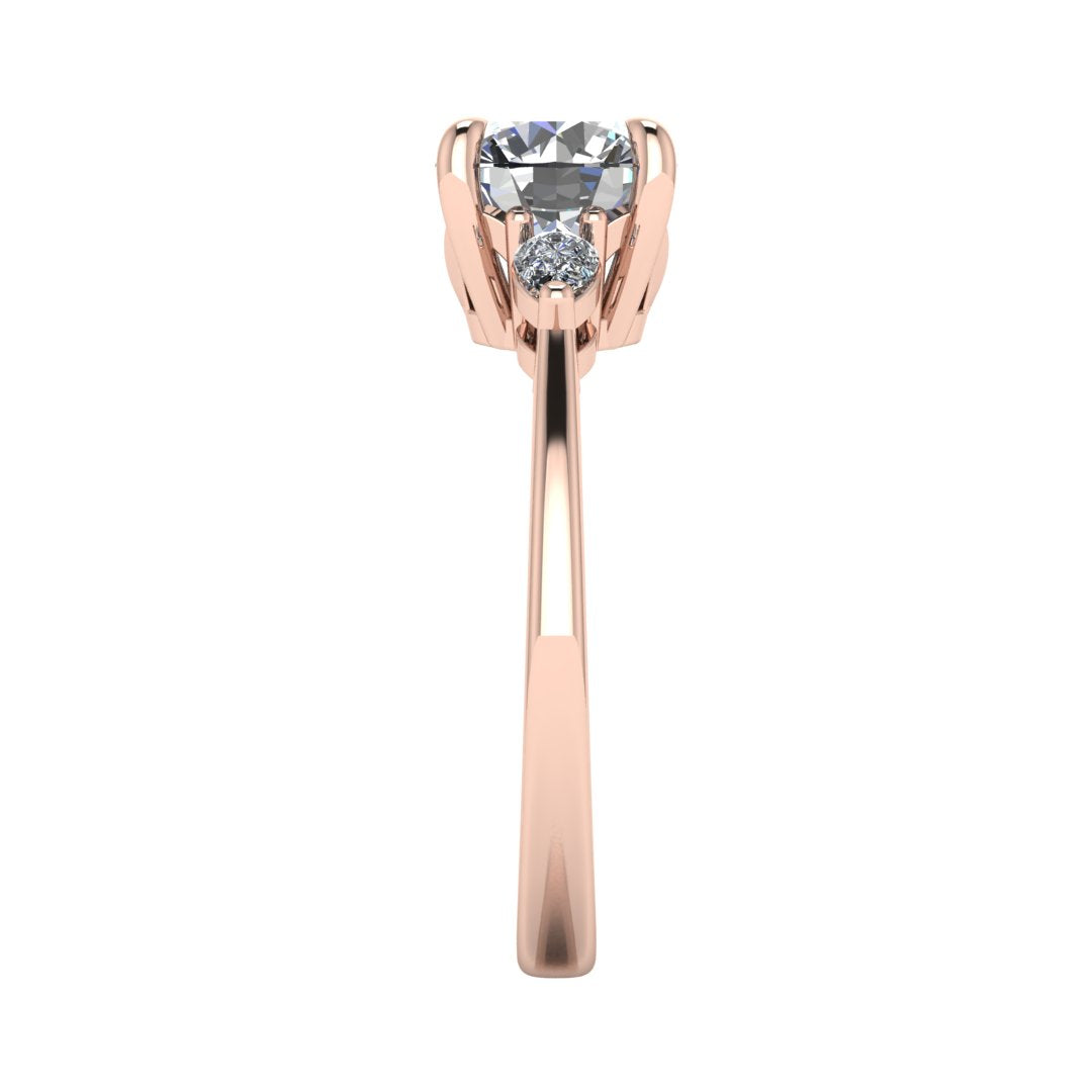 Side view of a rose gold trilogy engagement ring using round and pear shaped lab grown diamonds