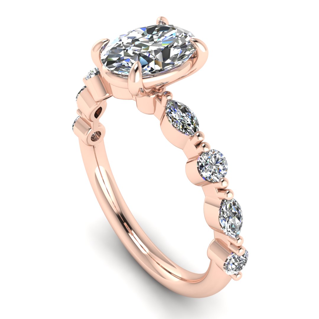 angled view of rose gold of Lily engagement ring with an oval cut centre stone surrounded by alternating smaller round and marquise stones on the shoulder