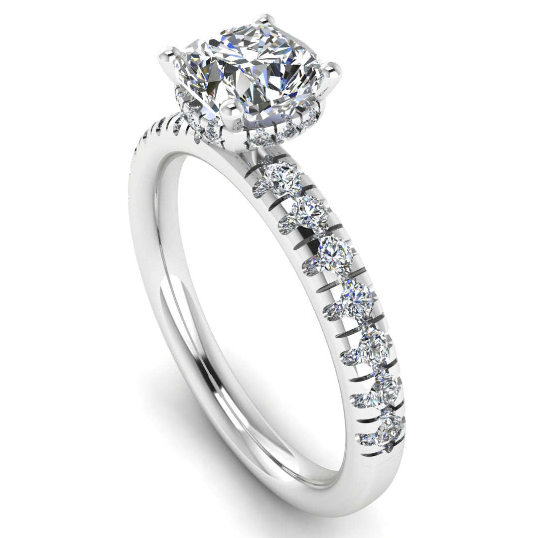 angled view of a platinum or white gold cushion cut lab grown diamond engagement ring with pavé shoulders and a hidden halo