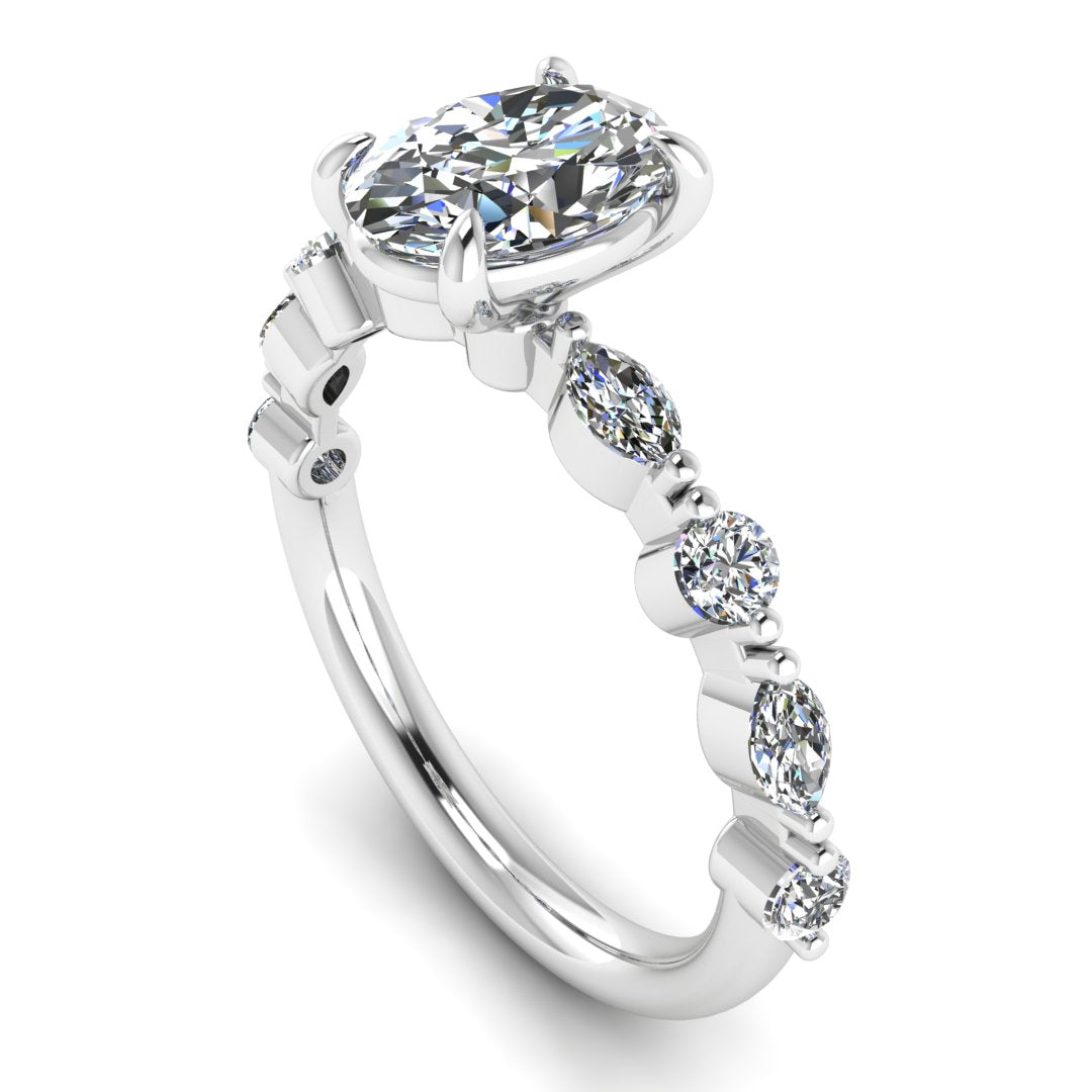 angled view of platinum or white gold of Lily engagement ring with an oval cut centre stone surrounded by alternating smaller round and marquise stones on the shoulder