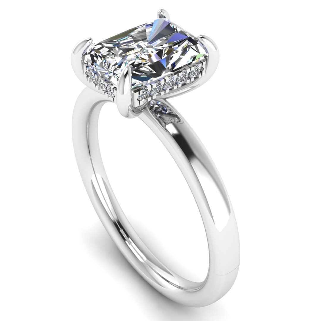 angled view of a platinum or white gold single solitaire engagement with set with a radiant cut lab grown diamond featuring a secret hidden under halo