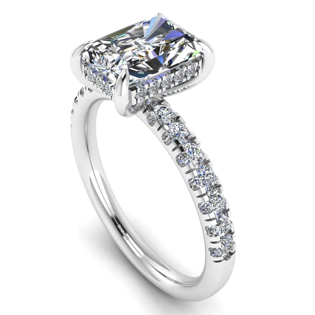 angled view of platinum or white gold engagement ring featuring a radiant cut lab-grown diamond with pavé-set shoulders and a hidden halo