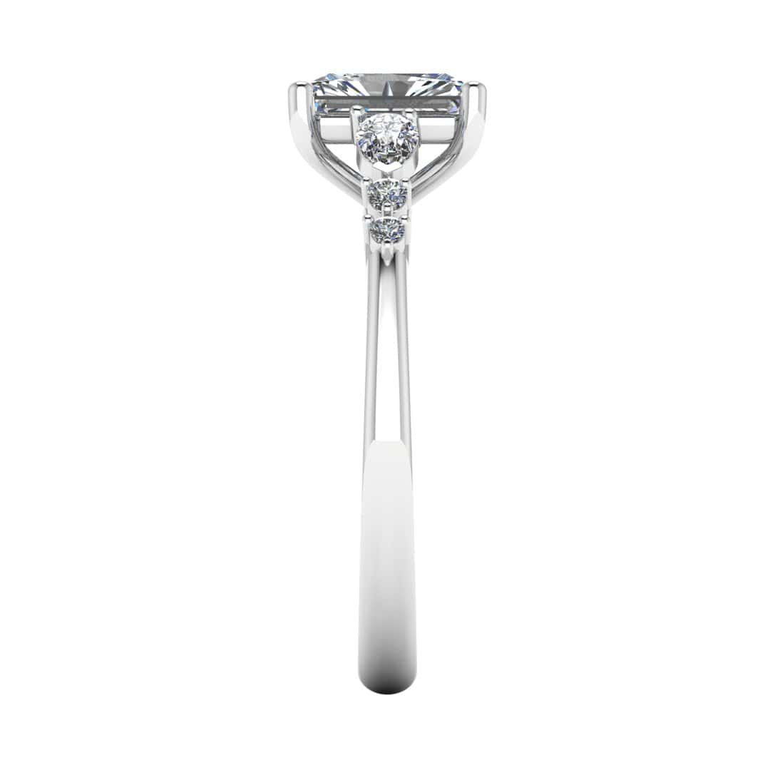 side view of a platinum or white gold multi-stone lab grown diamond engagement ring. It features a radiant cut lab-grown diamond with one pear and two round side diamonds on either side
