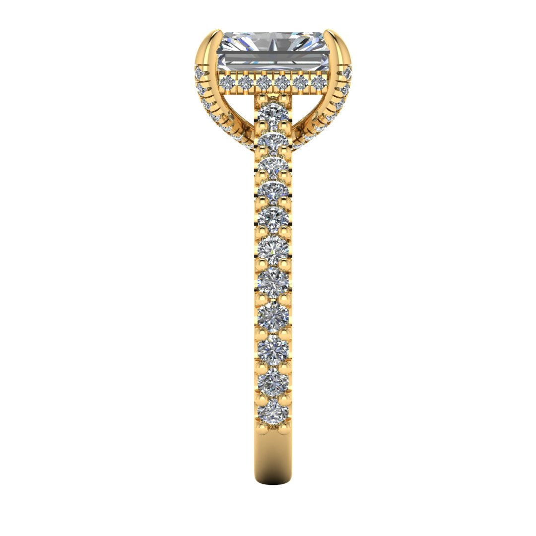 side view of Ellie yellow gold engagement ring which has a central emerald cut lab grown diamond, elegant under-halo, pavé-set shoulders, and delicate diamonds on the prongs for extra sparkle