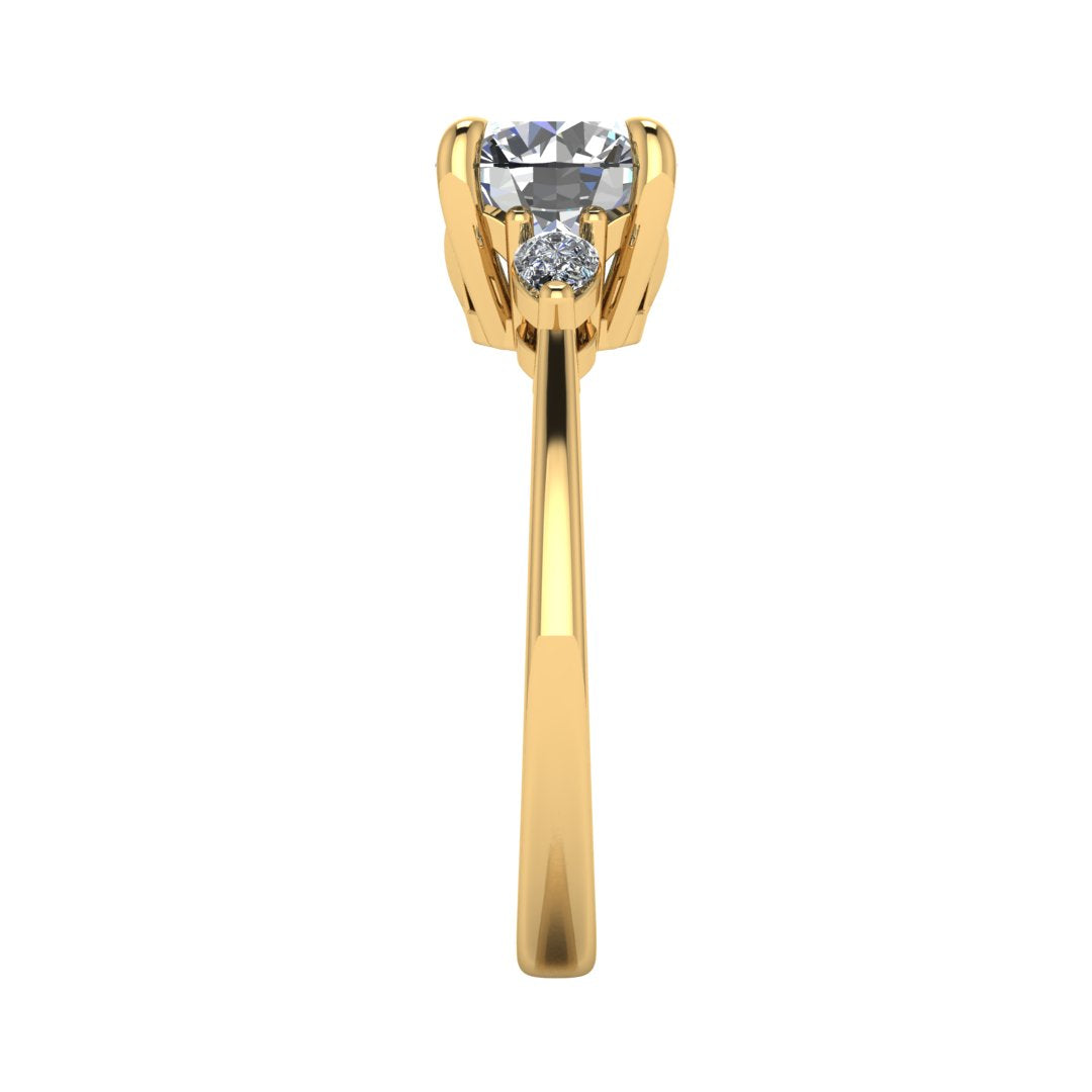 Side view of a yellow gold trilogy engagement ring using round and pear shaped lab grown diamonds