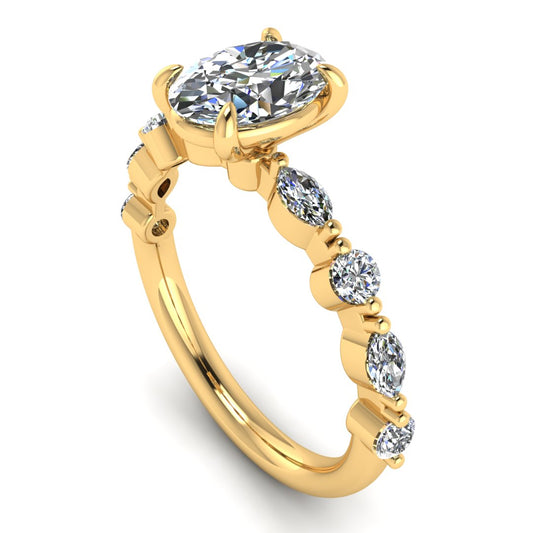 angled view of yellow gold of Lily engagement ring with an oval cut centre stone surrounded by alternating smaller round and marquise stones on the shoulder