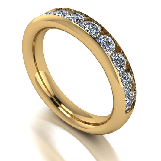 angled view of a yellow gold eternity ring or wedding band with round brilliant lab grown diamonds in a channel setting