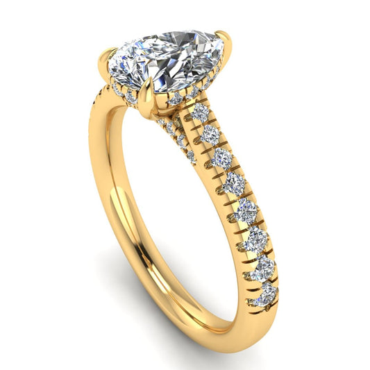 angled view of a yellow gold engagement ring, there is a pear cut centre lab grown diamond which has a hidden under halo and pavé-set diamond shoulders