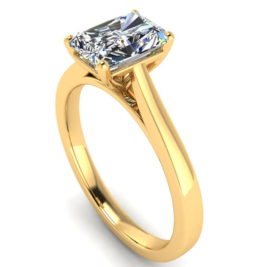 angled view of a yellow gold engagement ring set with a radiant cut lab grown diamond with 4 claws
