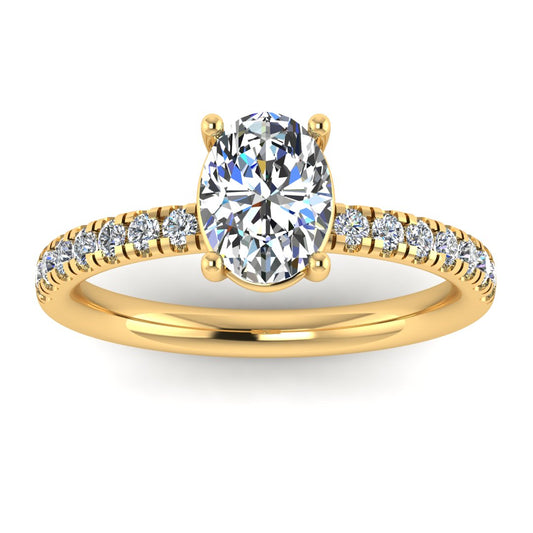 Angled view of yellow gold engagement ring with oval cut lab grown diamond set on a pave band with side shoulder stones