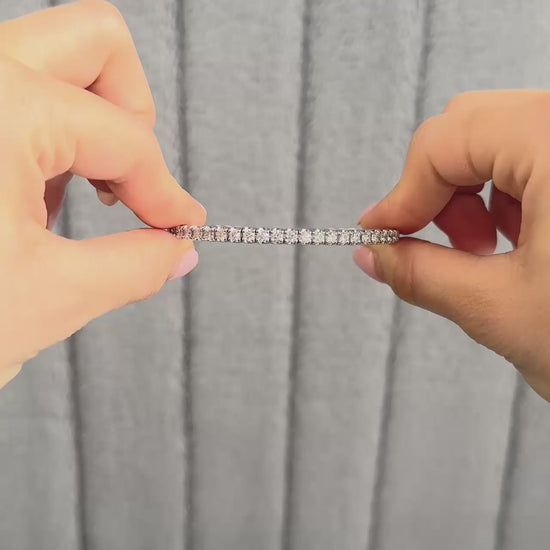lifestyle video showing flexible bangle in platinum or white gold. Model is opening the clasp and showing the flexibility in the bangle