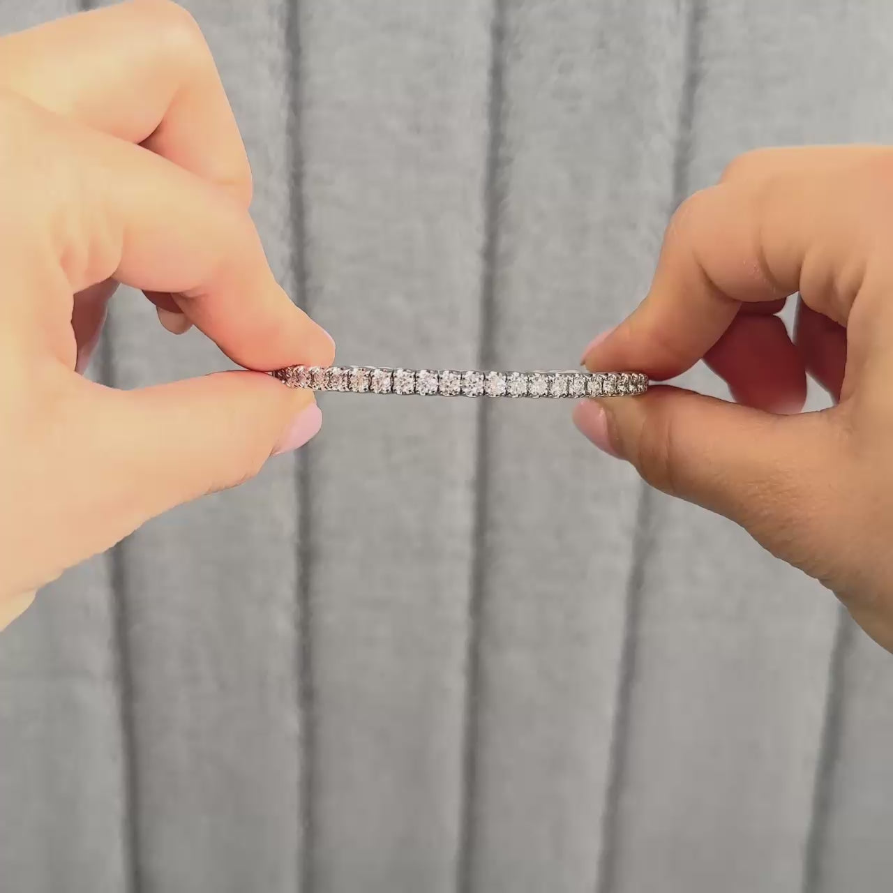 lifestyle video showing flexible bangle in platinum or white gold. Model is opening the clasp and showing the flexibility in the bangle