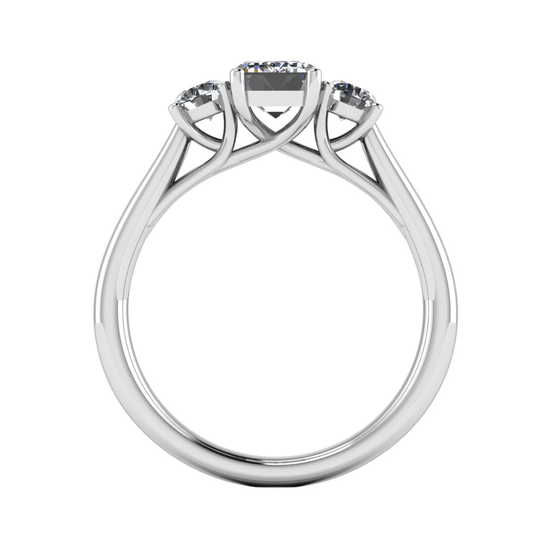 flat view of a trilogy platinum or white gold engagement ring set with an emerald centre lab grown diamond with two round brilliant diamonds on either side of the centre stone
