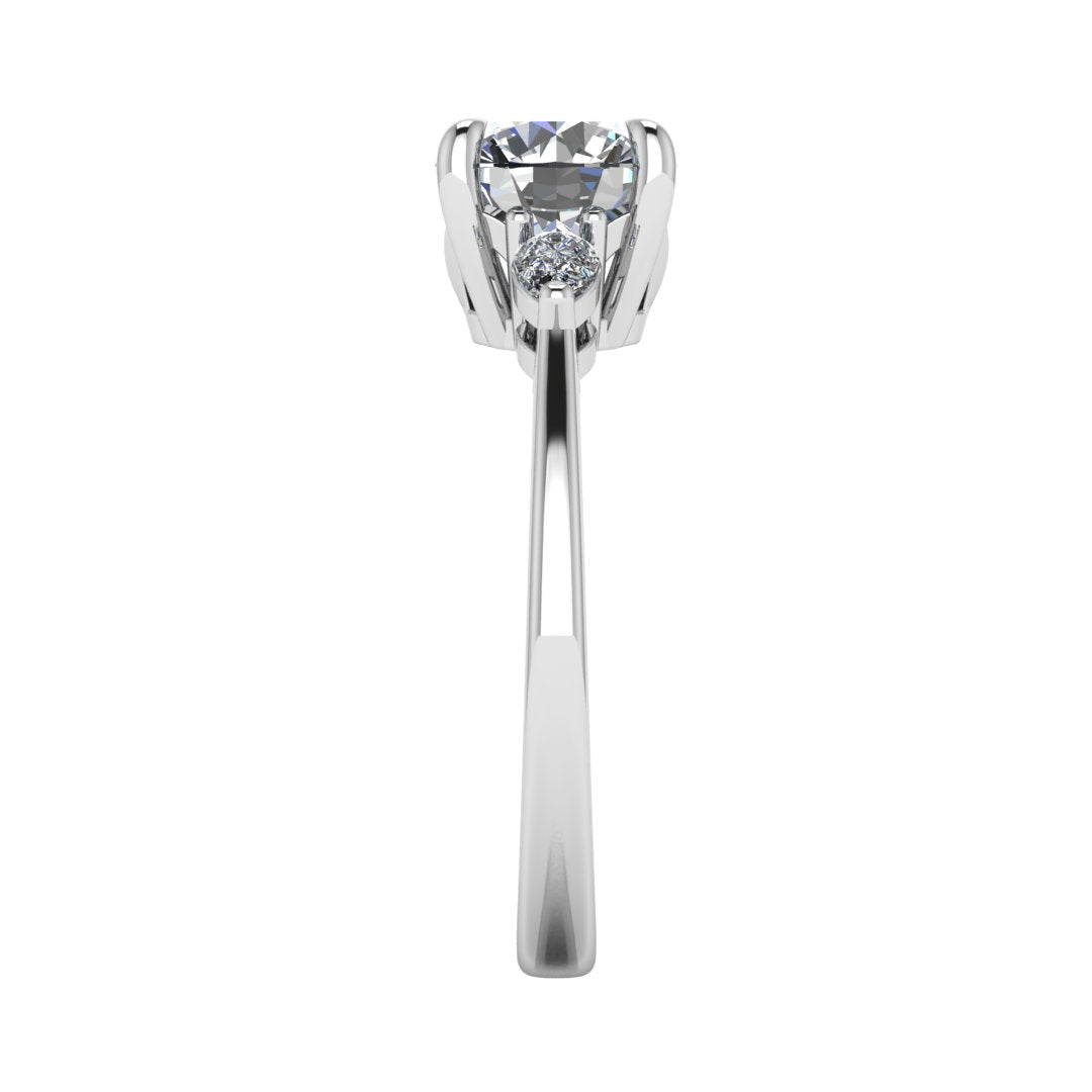 Side view of a white gold and platinum trilogy engagement ring using round and pear shaped lab grown diamonds