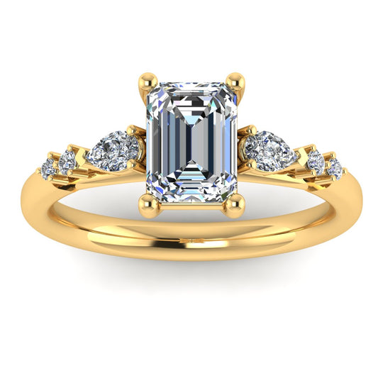 front view of yellow gold engagement ring. There is a emerald cut centre lab grown diamond with an arrangement of pear shaped and round diamonds on each side